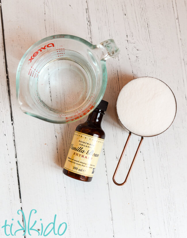 Vanilla cake soak recipe ingredients on a white wooden surface.