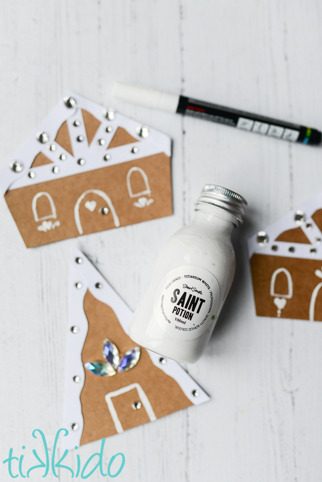 Stuart Semple Saint Potion white paint used to paint details on cardboard gingerbread house shapes.