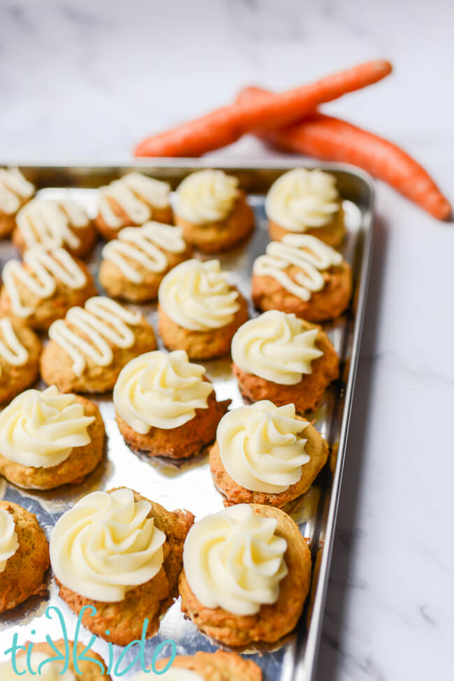 Baking tray filled with carrot cake cookies topped with cream cheese icing.