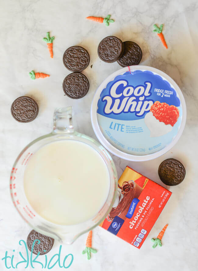 Ingredients for Spring Garden pudding parfaits, including Cool Whip, milk, pudding mix, Oreo cookies, and chocolate carrots.