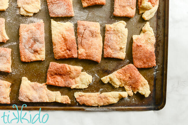 Cinnamon sugar pie crust scrap cookies baked on a cookie sheet.