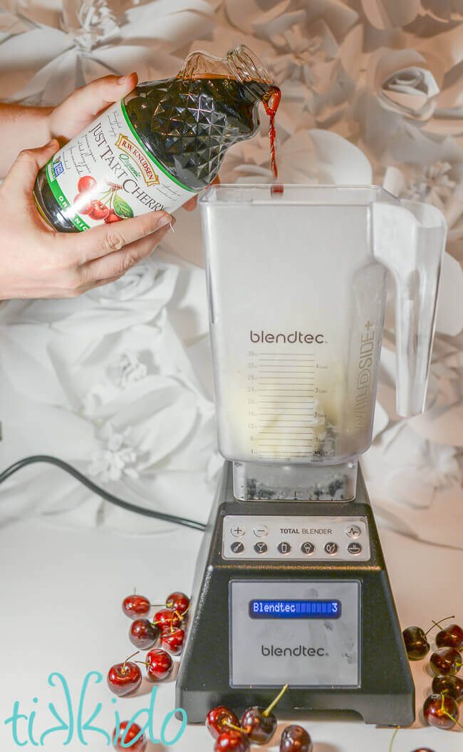 Cherry juice being poured in a Blendtec blender to make a cherry milkshake