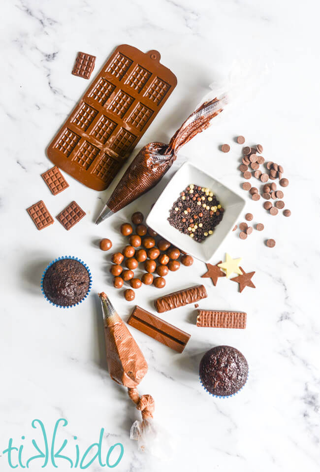 Materials for making Chocolate Explosion Cupcakes on a white marble surface.