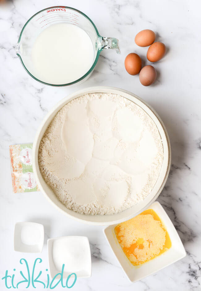 cinnamon roll recipe ingredients on a white marble surface.