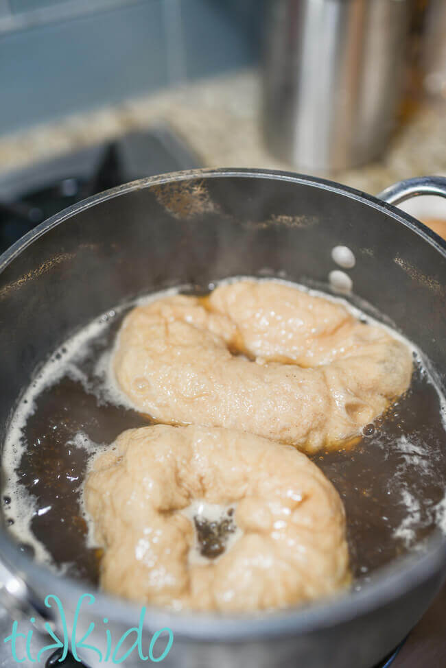 Cinnamon bagels being boiled before baking.