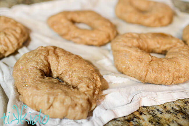 Cinnamon bagels boiled and resting on a clean kitchen towel.
