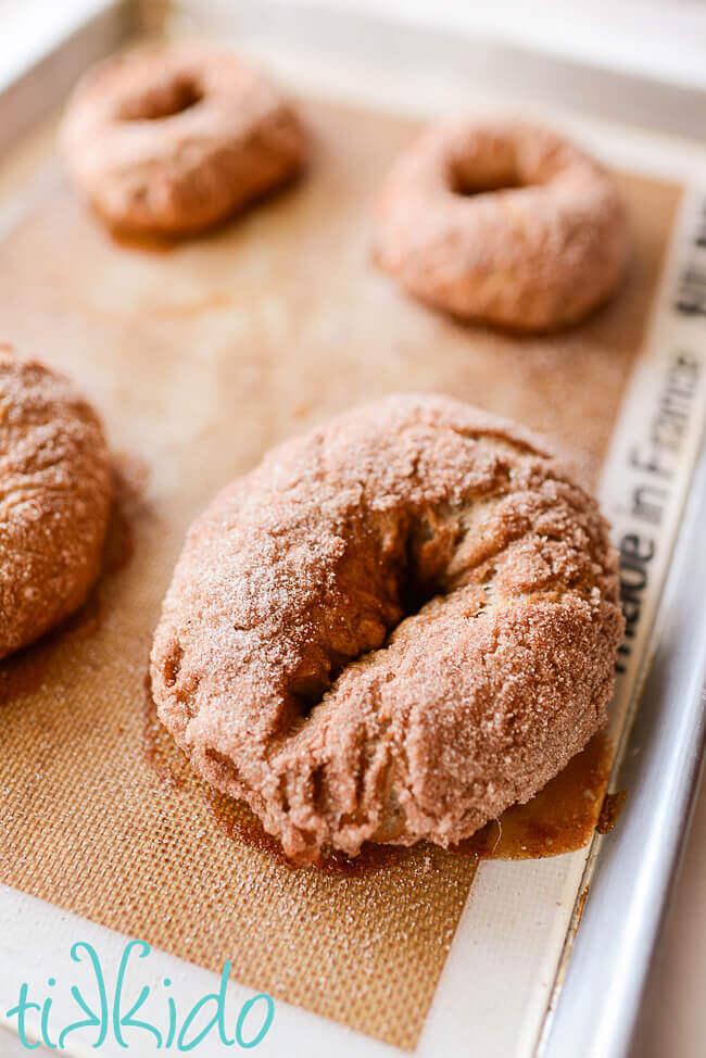 Baked cinnamon sugar bagels on a silpat lined baking sheet.