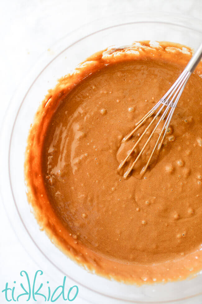 Coffee cupcakes batter in a clear pyrex bowl with a whisk.