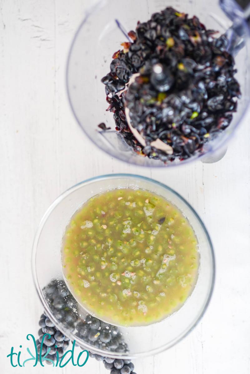 Concord grapes separated into two bowls, one holding the skins, one holding the fruit and juice.