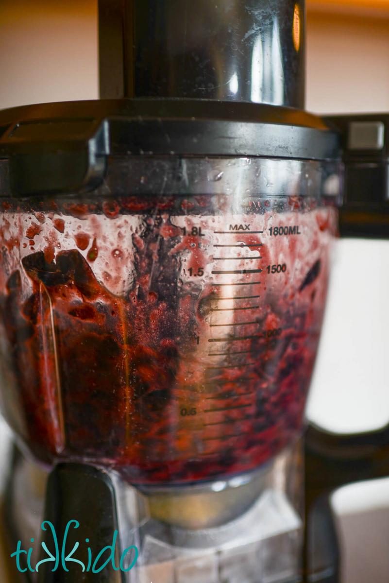 Concord grape skins being chopped in a food processor.