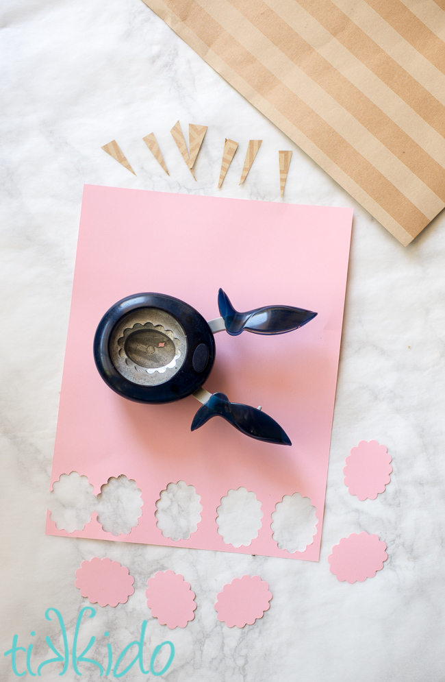 Scrapbook paper being used to make cotton candy shaped paper embellishments for a cotton candy birthday party.