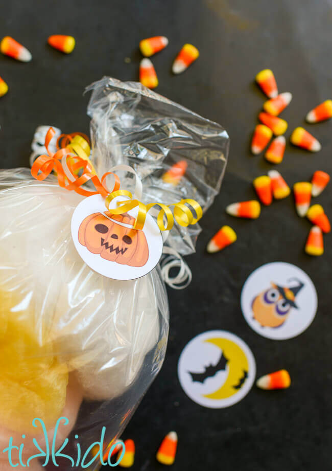 Jack-o-lantern Halloween gift tag on a bag of cotton candy, tied on with curling ribbon.