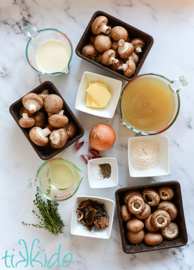 Ingredients for a Cream of Mushroom Soup Recipe on a white marble surface.