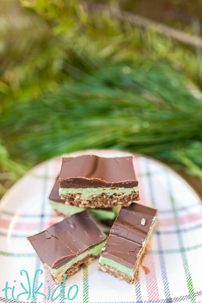 Four no bake mint chocolate bars on a plaid plate.