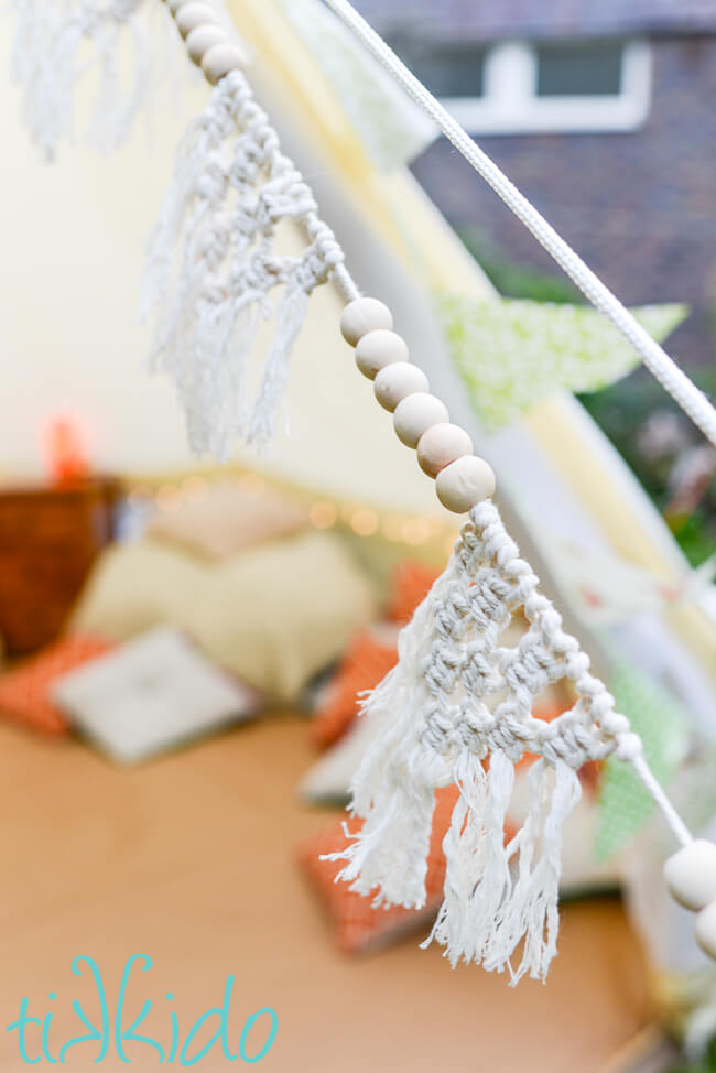 Macrame bunting hung outside of a bell tent at a bohemian crystal themed birthday party.