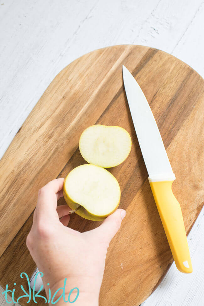 Apple sliced on a wooden cutting board using pastry chef apple slicing methods.