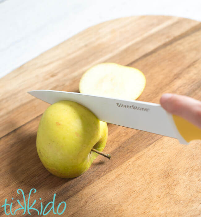 Apple sliced on a wooden cutting board using pastry chef apple slicing methods.