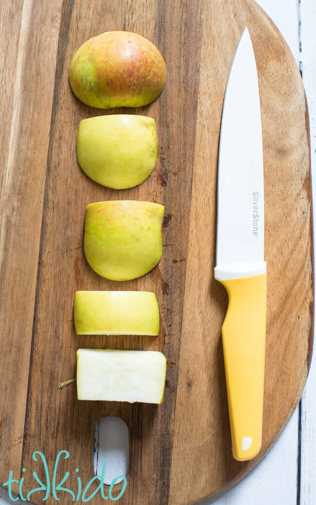 Apple sliced on a wooden cutting board using pastry chef apple slicing technique..
