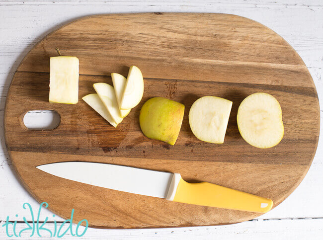 Apple sliced on a wooden cutting board using pastry chef apple slicing methods.