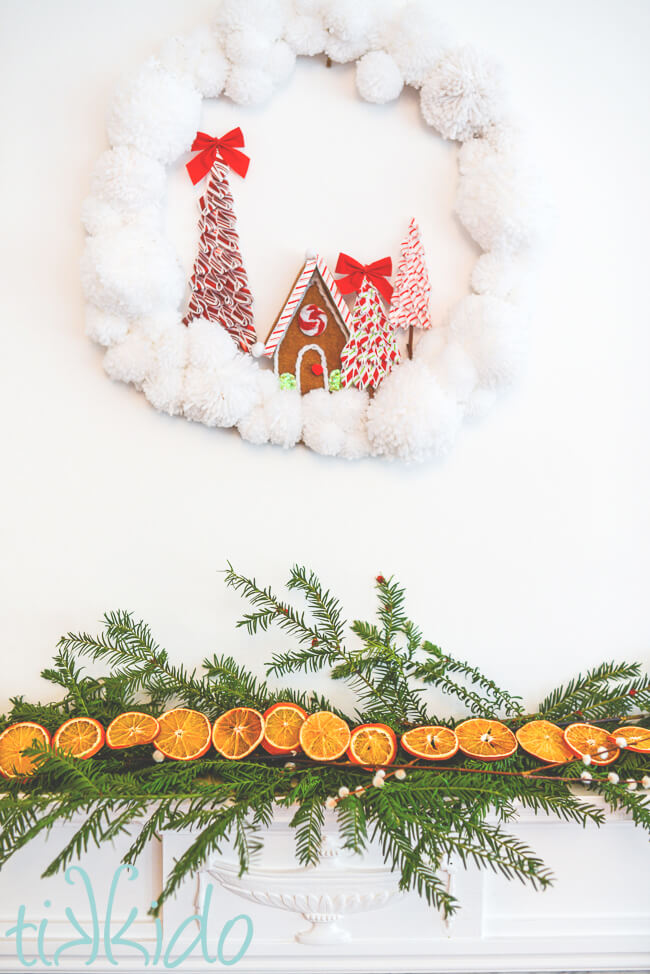 Dried Orange Garland nested on a bed of fresh evergreen branches, decorating a fireplace mantel.