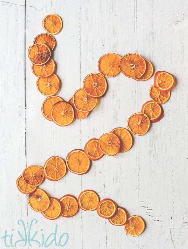 Dried orange garland on a white wooden background.