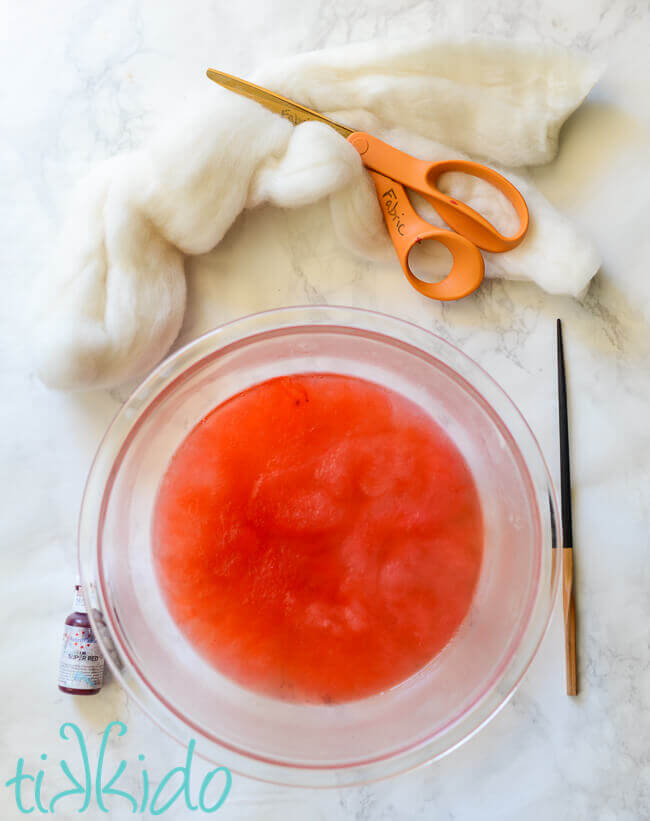 Wool roving being dyed red with food coloring