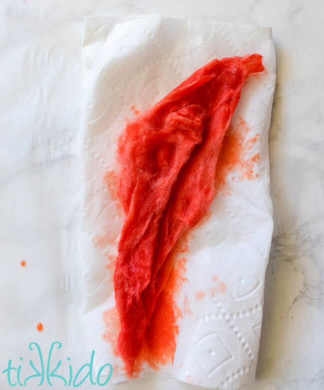 Dyed red wool roving drying on a paper towel.