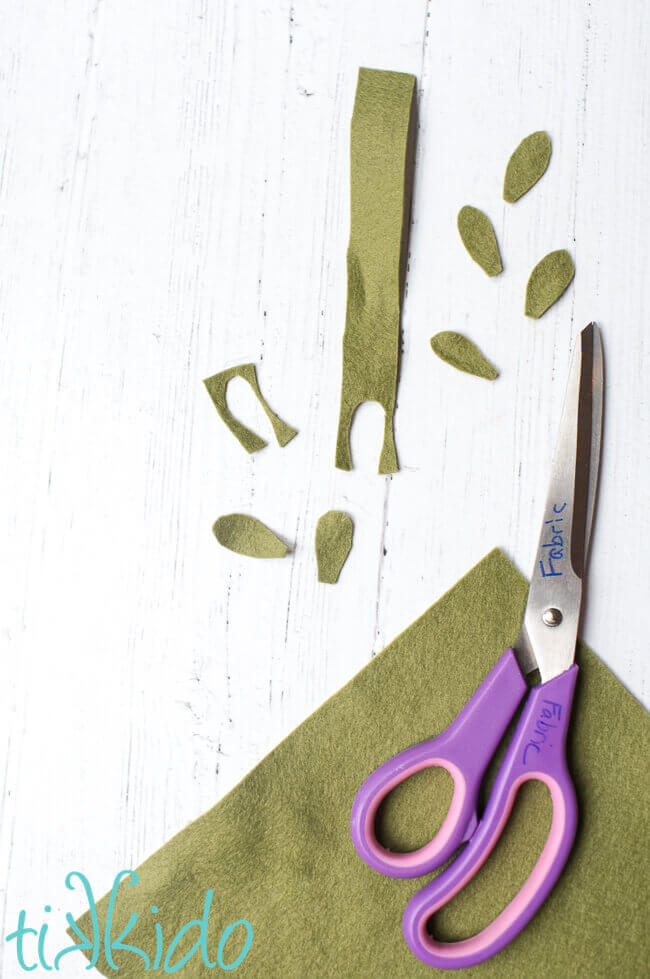 Green felt being cut into mistletoe leaves for the Mistletoe Ornament