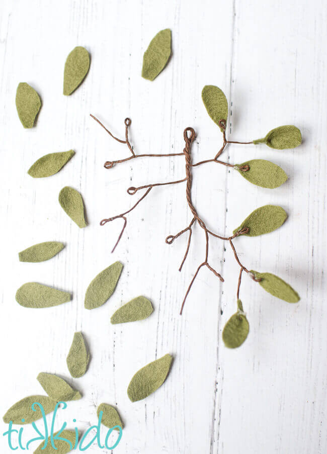 Felt leaves being glued to a wire form to make a Mistletoe Ornament