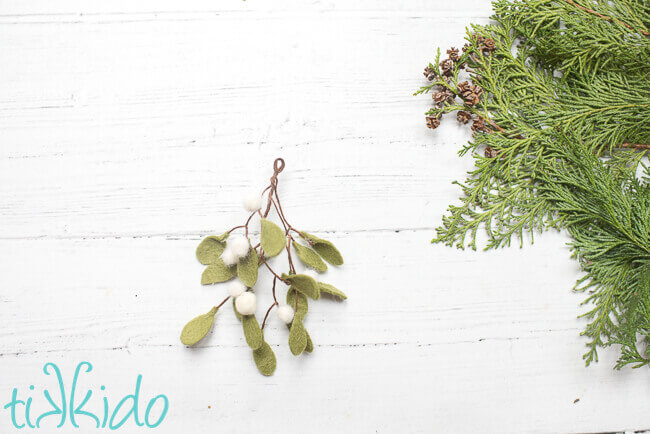 Felt mistletoe  ornament on a white wooden background