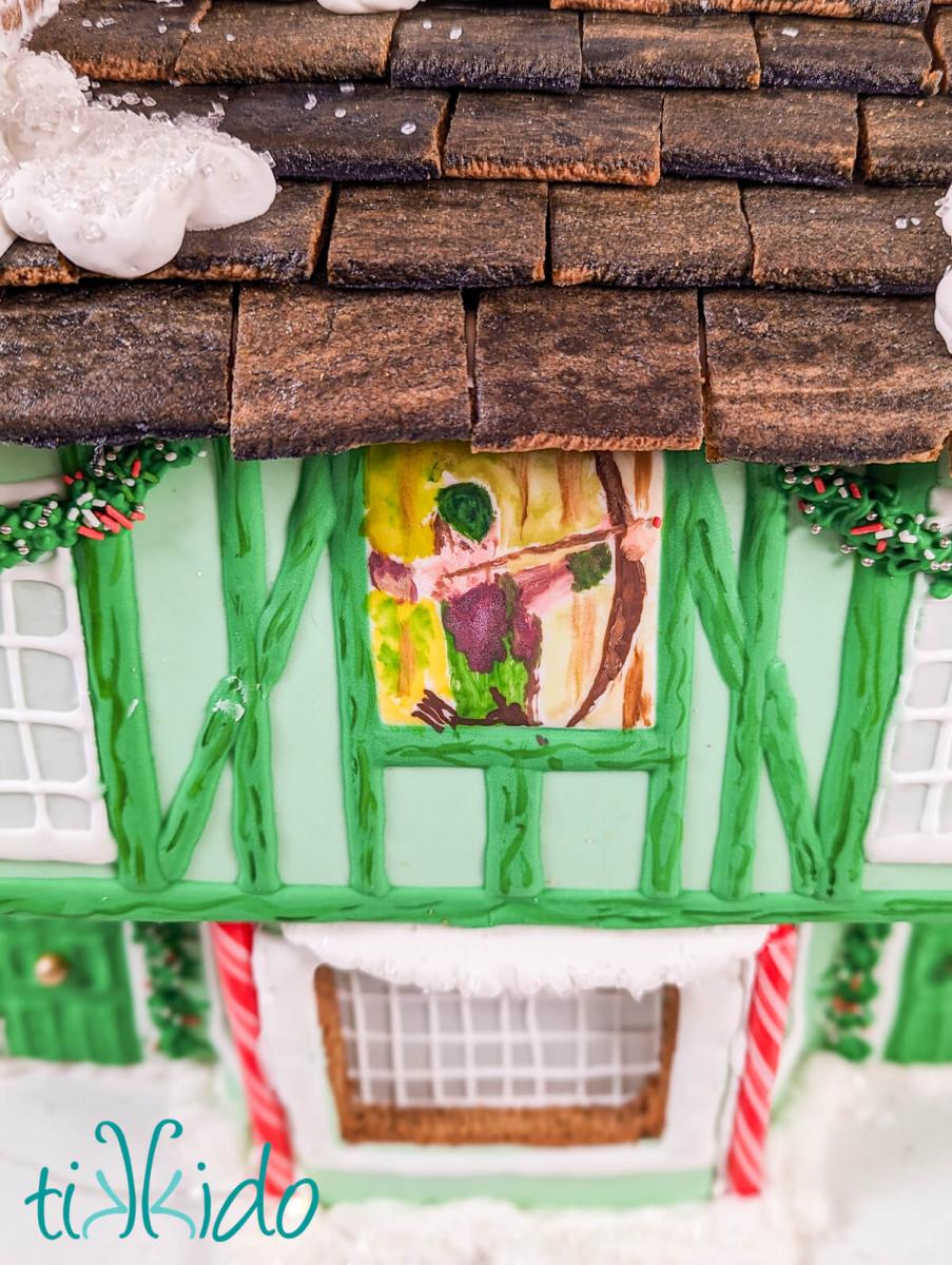 Closeup of the hand-painted Robin Hood sign on the gingerbread Robin Hood pub.  It is painted with food coloring and is entirely edible. 