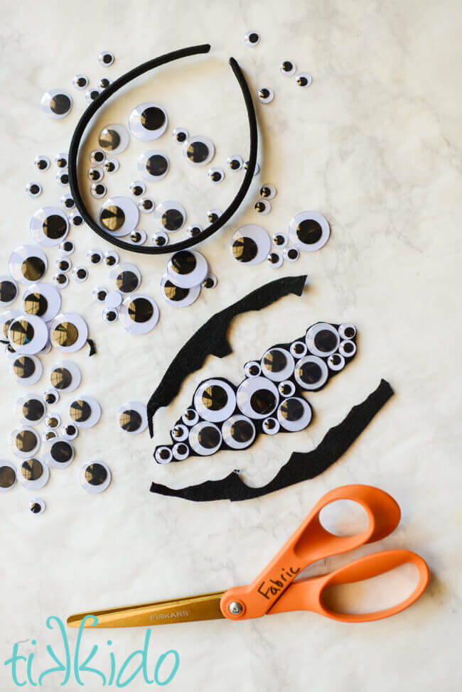 Googly eyes Halloween headband being trimmed to shape.