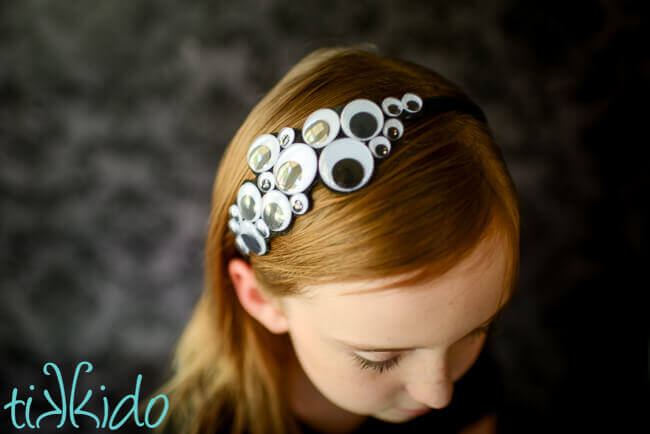 Girl wearing a Googly eyes Halloween headband.