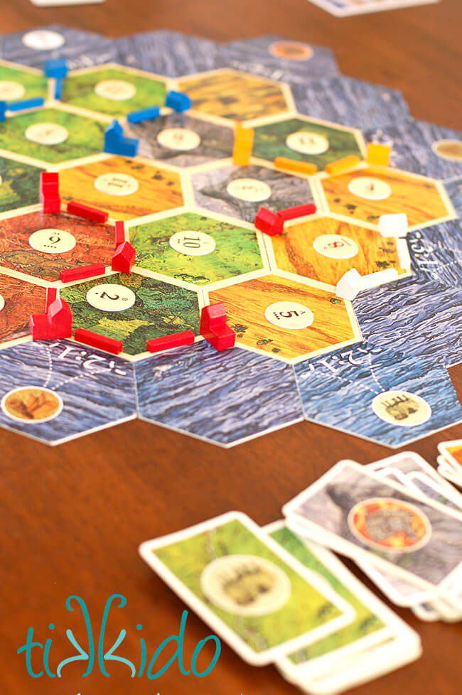 Settlers of Catan board game set up on a wooden table.