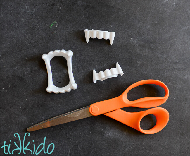 Plastic vampire teeth cut into two pieces.