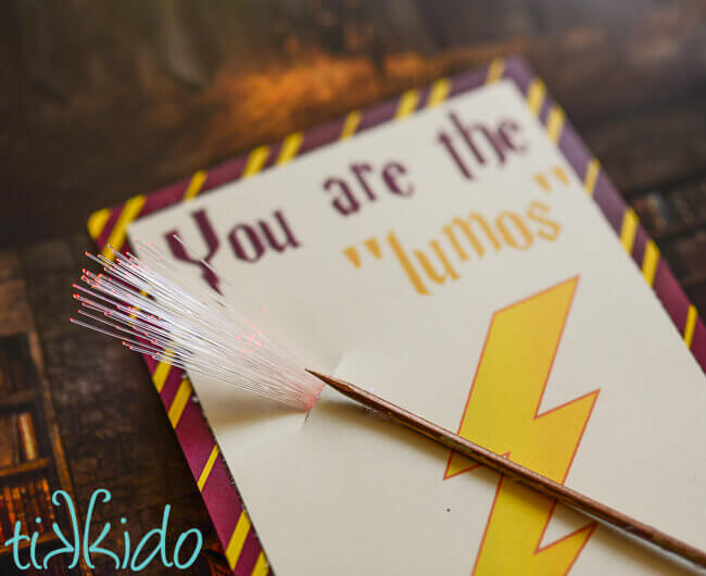 Close up of LED fiber optic finger light appearing to come out of the tip of a miniature wand on a Harry Potter printable valentine