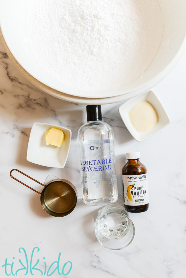 Ingredients for making homemade fondant recipe on a white marble surface.