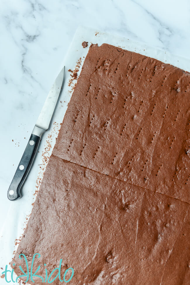 Homemade ice cream sandwich cookies baked and being cut into two large slabs.