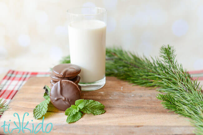 Stack of homemade thin mints cookies next to a tall glass of milk.