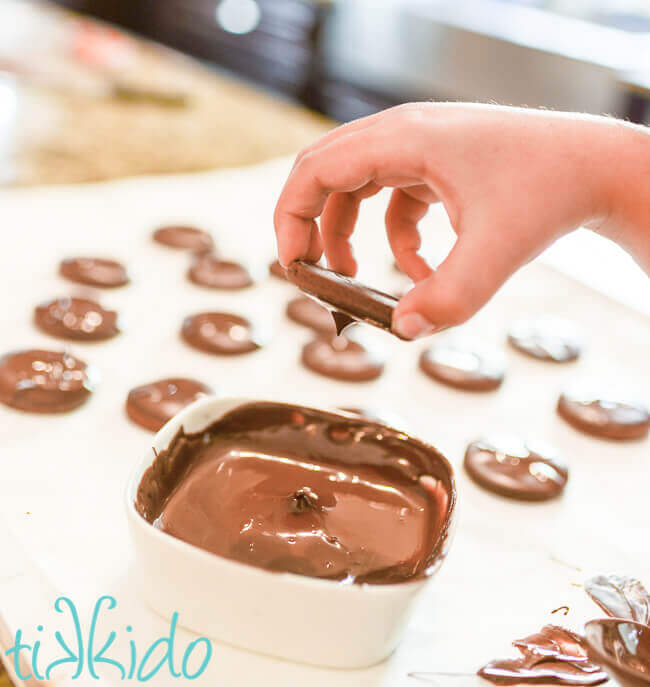 Homemade thin mints being dipped in chocolate.