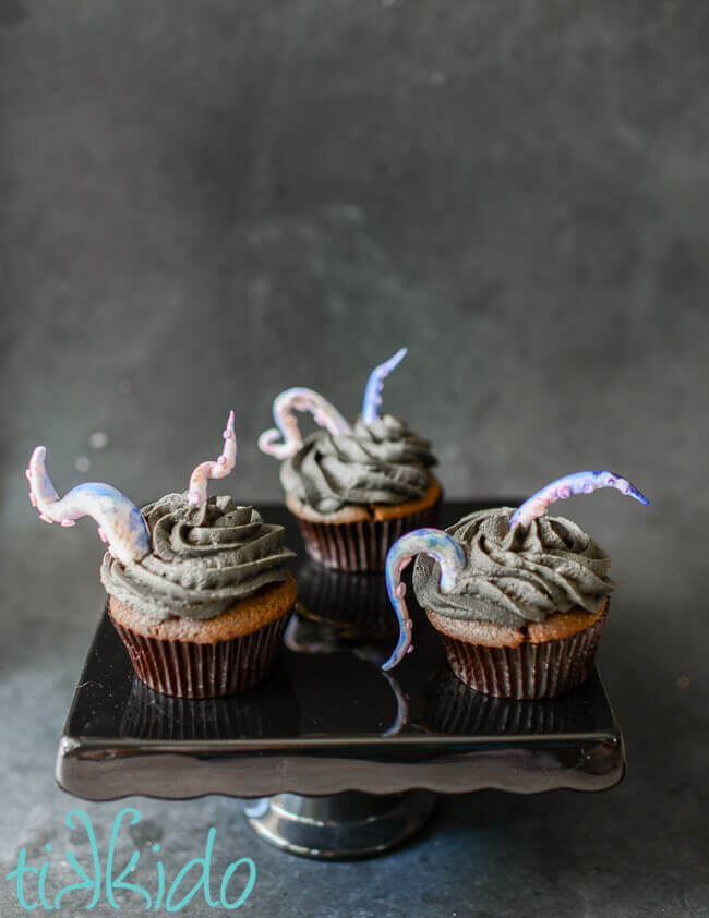 Gum paste tentacles rising out of black chocolate icing on chocolate cupcakes.