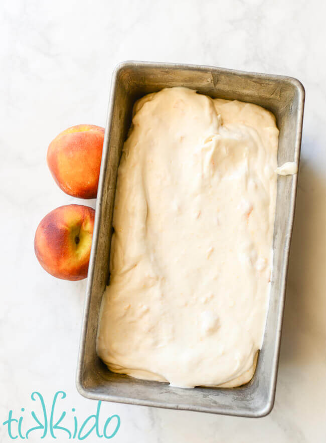 No churn peach ice cream ready to freeze in a metal bread pan.