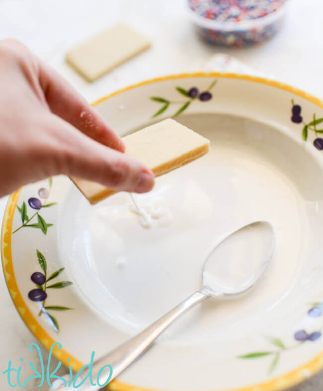 Dipping sugar cookies in royal icing