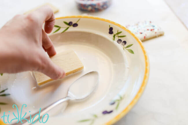 Dipping sugar cookies in royal icing