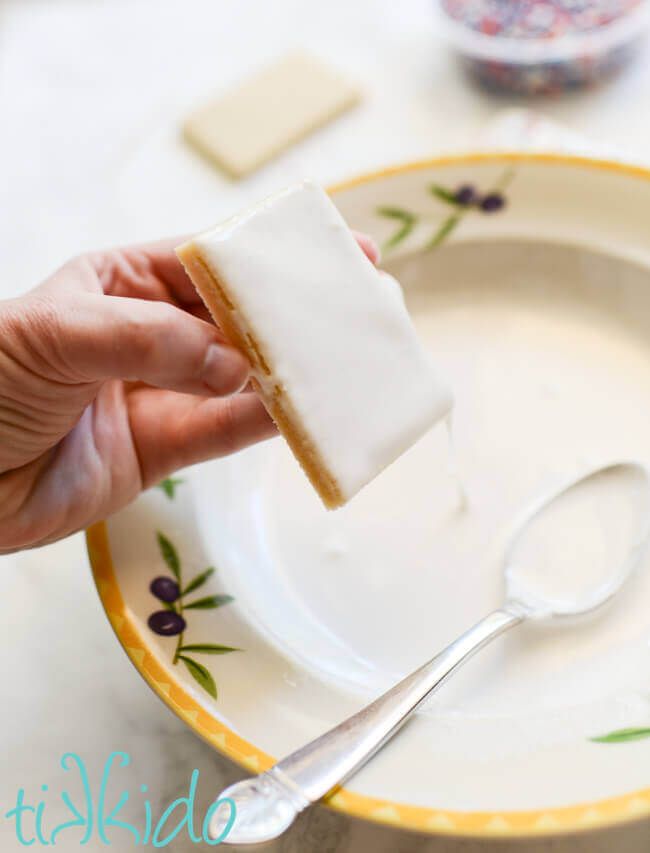 Dipping sugar cookies in royal icing