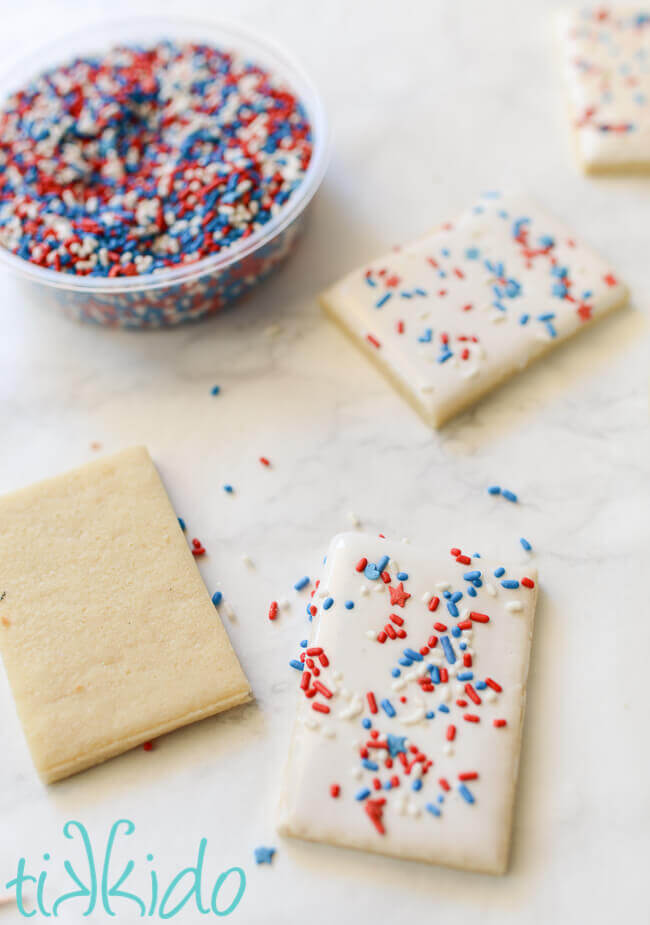 Sugar cookies coated in royal icing and covered in patriotic, red white and blue sprinkles.