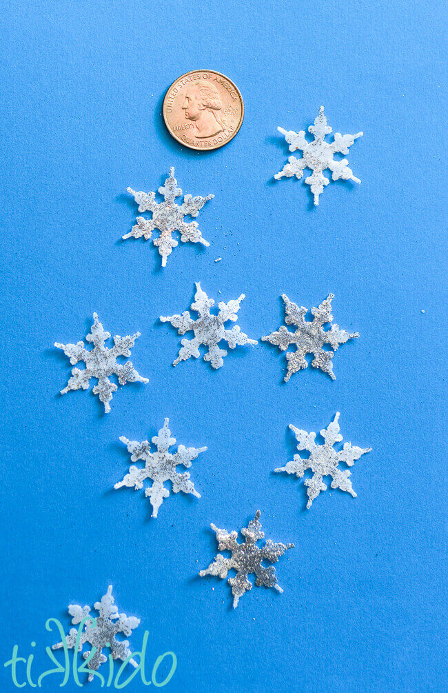 Single Use snowflake soaps shown with a quarter for scale on a blue background.