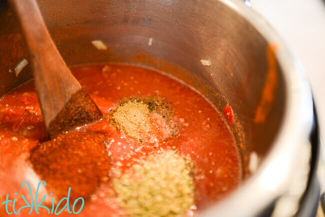 Ingredients for Instant pot chili being stirred in an open Instant Pot.