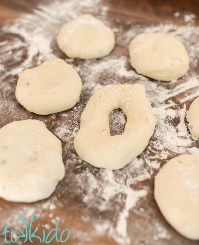 Jalapeño Cheddar Bagels being shaped into rings on a floured countertop.