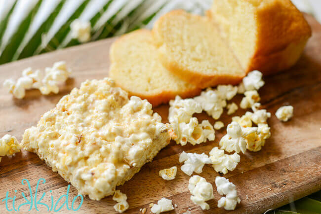 Pound Cake Popcorn Bar on wooden cutting board, surrounded by pound cake and popcorn.